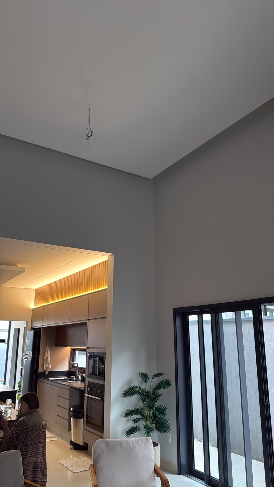 Ponto de luz preparado no teto de uma sala de pé-direito alto antes da instalação